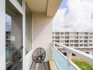 a balcony with two chairs and a view of a building at Apartment near North Sea and Lighthouse in Egmond aan Zee