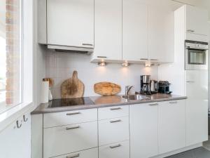 a white kitchen with white cabinets and a sink at Apartment near North Sea and Lighthouse in Egmond aan Zee