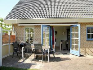 a patio with a table and chairs in front of a house at Holiday Home in Schoorl near Sandy Beaches in Schoorl