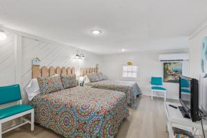 a bedroom with two beds and a flat screen tv at Dave's Last Resort - Poolside Cabin 4 Hotel Room in Monticello