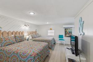 a bedroom with two beds and a flat screen tv at Dave's Last Resort - Poolside Cabin 4 Hotel Room in Monticello