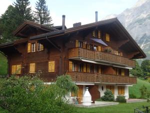 a large wooden house with a balcony at Haus Sapporo in Grindelwald