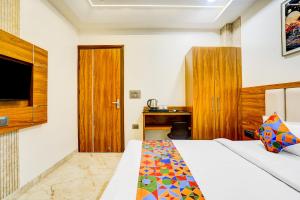 ブリンダーバンにあるFabHotel Kishori Innのベッドとテレビがあるホテルの部屋