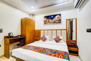 una camera da letto con un letto e una scrivania di FabHotel Kishori Inn a Vrindāvan