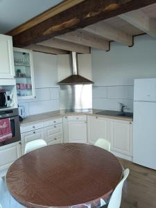 a kitchen with a wooden table and white cabinets at J&P's Home in Férel