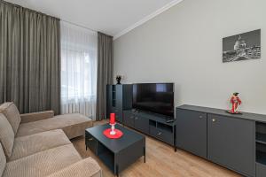 a living room with a couch and a flat screen tv at The Comfort Apartment #1 by Polo Apartments in Kaunas