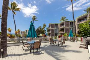a patio with tables and chairs and umbrellas at Incredible Ocean Views in Kailua-Kona