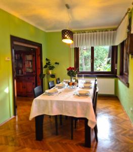una sala da pranzo con tavolo e tovaglia bianca di Vila Moka near Bled-Entire place with Garden Retreat a Lesce
