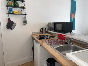 サン・ジュニアンにあるStudio meublé centre-ville Saint Junienのシンクと電子レンジ付きのキッチン +5枚の写真