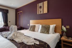 a bedroom with a large bed with white sheets at Passage House Hotel in Newton Abbot