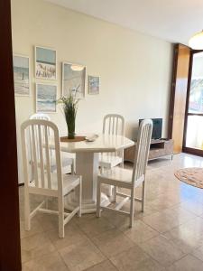 a dining room with a white table and chairs at Varandas do Pinhal in Fão +8 photos