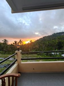 a balcony with a view of the sunset at Laras Homestay Munduk in Munduk +21 photos