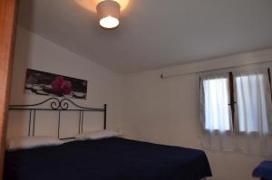 a bedroom with a black bed and a window at Fpo-Rose02p1 in Porto Ottiolu