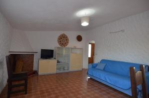 a living room with a blue couch and a tv at Fpo-Rose02p1 in Porto Ottiolu