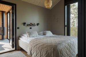 Un dormitorio con una cama y una ventana grande. en Villa Arctic Trail, Apartment A, en Äkäslompolo
