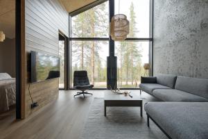 una sala de estar con un sofá y una silla en Villa Arctic Trail, Apartment A, en Äkäslompolo