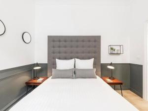a bedroom with a large white bed with two lamps at El Príncipe de neón in Alomartes