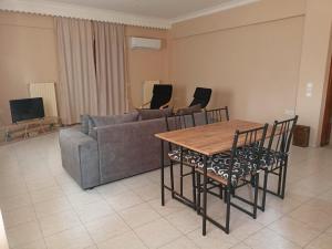 a living room with a couch and a table and chairs at Poseidon seaside home 2 in Ireo in Ireon