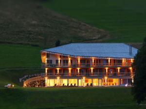 a large building on a golf course at night at derWaldfrieden naturparkhotel in Herrenschwand