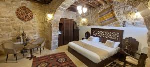 a bedroom with a large bed and a table and chairs at Hayat Zaman Hotel And Resort Petra in Wadi Musa