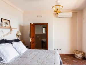a bedroom with a bed and a chandelier at VitaLenta in Naxos in Giardini Naxos