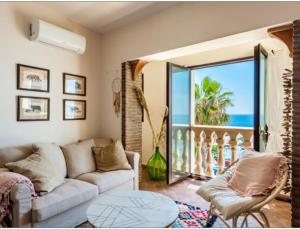 a living room with a couch and a view of the ocean at VitaLenta in Naxos in Giardini Naxos