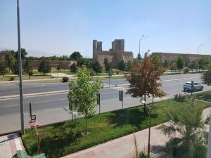 an empty street with a road in front of a building at Zamin Hotel in Shahrisabz