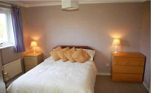 a bedroom with a bed with two night stands and two lamps at Shared Double Rooms in Buckinghamshire