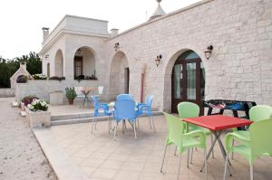 a patio with colorful chairs and tables and a building at Cuore dei Venti in Martina Franca