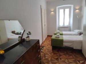 een slaapkamer met 2 bedden, een wastafel en een spiegel bij Galleria sul Mare in Trieste