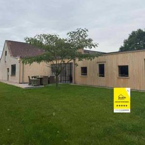 a house with a yellow sign in the grass at Huisje Nostalgie in Laakdal