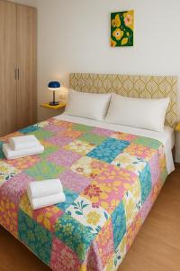 una cama con una colcha de colores encima en SYL guest house centro ciudad, en Jaén
