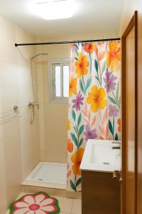 Un baño con una cortina de ducha con flores. en SYL guest house centro ciudad, en Jaén