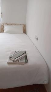 Una cama blanca con una bandeja encima. en SYL guest house centro ciudad, en Jaén