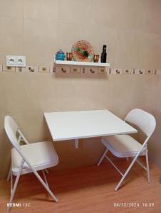 una mesa blanca y 2 sillas en una habitación en SYL guest house centro ciudad, en Jaén