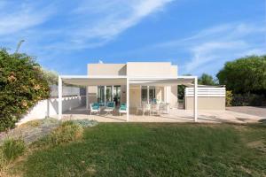 a white house with chairs and a patio at Villa Luisa in Noto Marina +15 photos