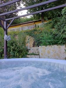a hot tub in a backyard with a pergola at Fecskefészek vendégház in Nagymaros