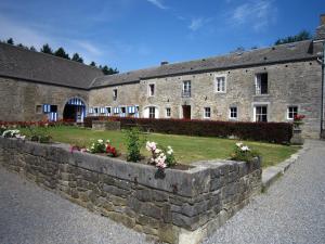 a stone wall with flowers in front of a building at Cosy Cottage in Barvaux-Condroz with Garden in Barvaux-Condroz
