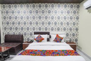 una camera da letto con un letto e un divano di FabHotel Rajdhani a Kānpur