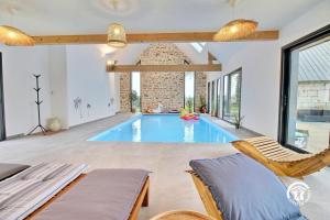 einen Pool in einem Wohnzimmer mit 2 Stühlen in der Unterkunft Les maisons de l'if - l'escapade in Pluméliau
