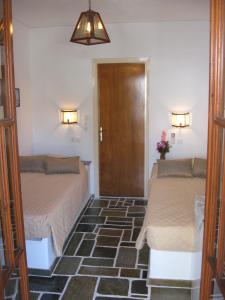 una camera con due letti e una porta per una camera da letto di Pension Irini-Vicky a Ios Chora