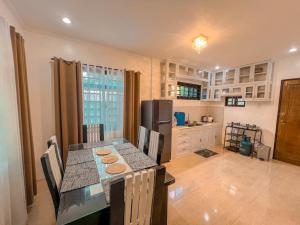 eine Küche mit Tisch, Stühlen und Kühlschrank in der Unterkunft Cordon, Isabela Staycation House in Cordon