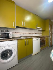 eine Küche mit gelben Schränken und einer Waschmaschine in der Unterkunft San Pedro in Teruel
