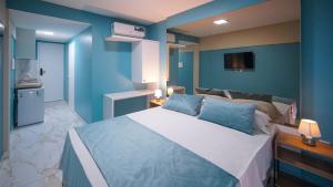 a bedroom with a large bed with blue walls at Davila Flat Hotel in Fortaleza +34 photos