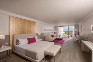 Platinum Yucatan Princess Adults Only - All Inclusive في بلايا ديل كارمن: غرفة نوم بها سرير كبير وغرفة معيشة