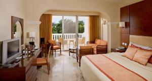 a hotel room with a bed and a living room at Grand Riviera Princess - All Inclusive in Playa del Carmen