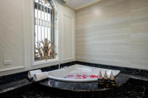 a bathroom with a large bath tub with a window at Riverside Hotel Đông Anh in Dong Anh +41 photos