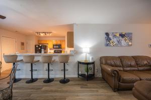sala de estar con sofá y cocina con encimera. en Welcome to Charlotte Nest!, en Charlotte