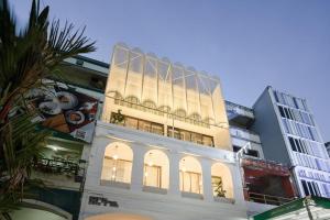 ein hohes Gebäude mit einer beleuchteten Fassade in der Unterkunft Our Nomad Boutique Hostel in Phuket