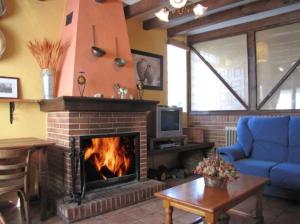 a living room with a fireplace and a blue couch at El Arreñal del Cañón del Río Lobos in Santa María de las Hoyas